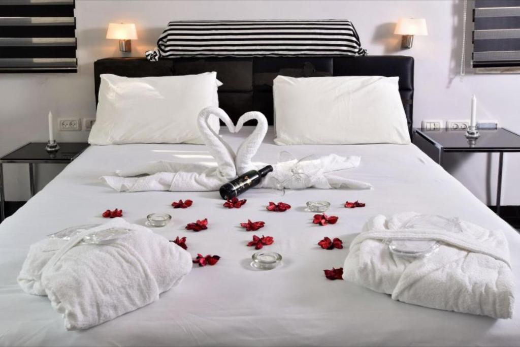 Black&White Had Ness في هاد نيس: سرير عليه مناشف بيضاء وورود حمراء