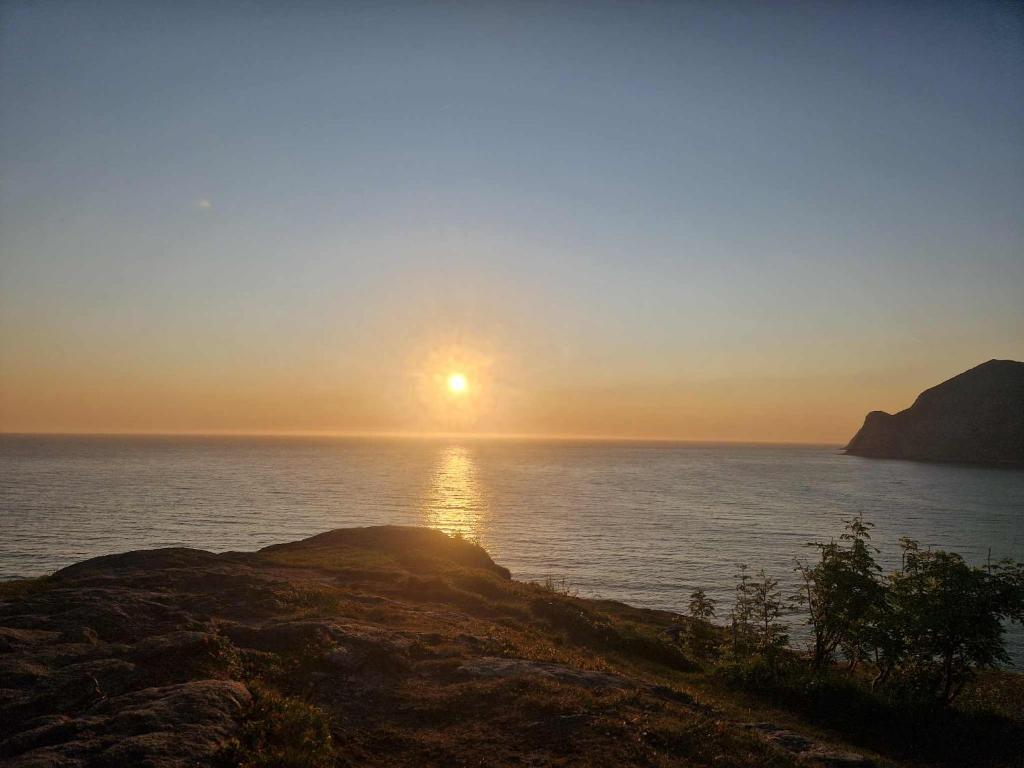 a sunset over the ocean with the sun setting at Camp Mefjord in Senja