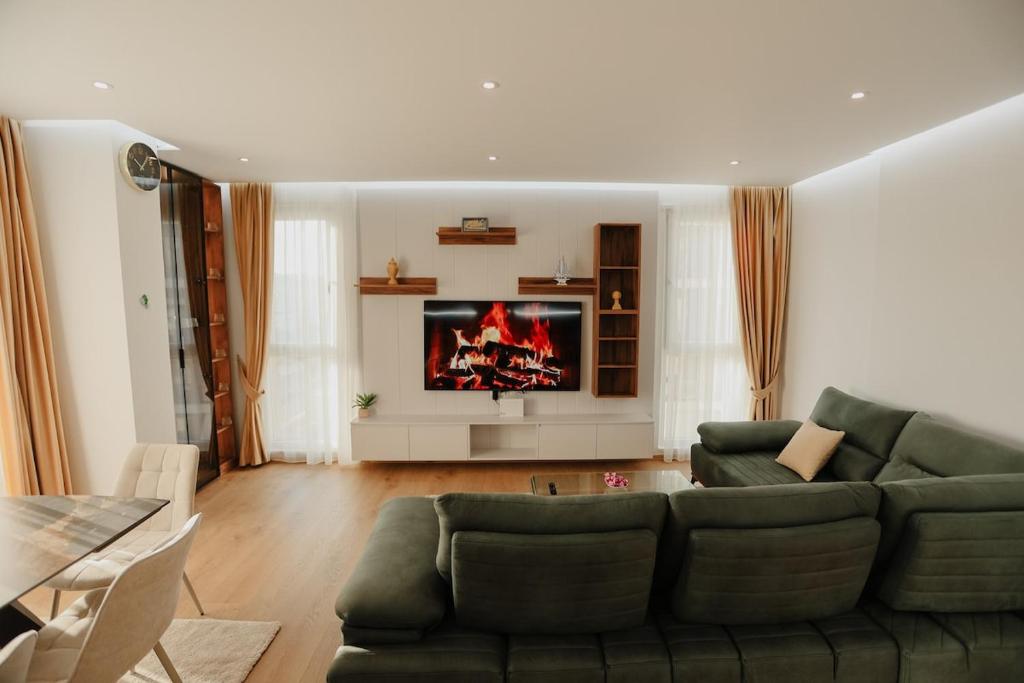 TiraneにあるAri Luxury Apartmentの緑のソファとテレビのあるリビングルーム