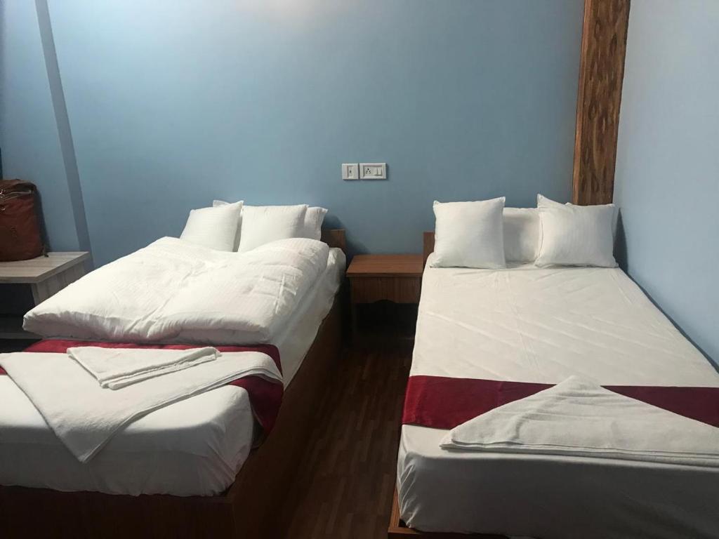 zwei Betten in einem Zimmer mit blauen Wänden in der Unterkunft ColdFeet Home in Kathmandu