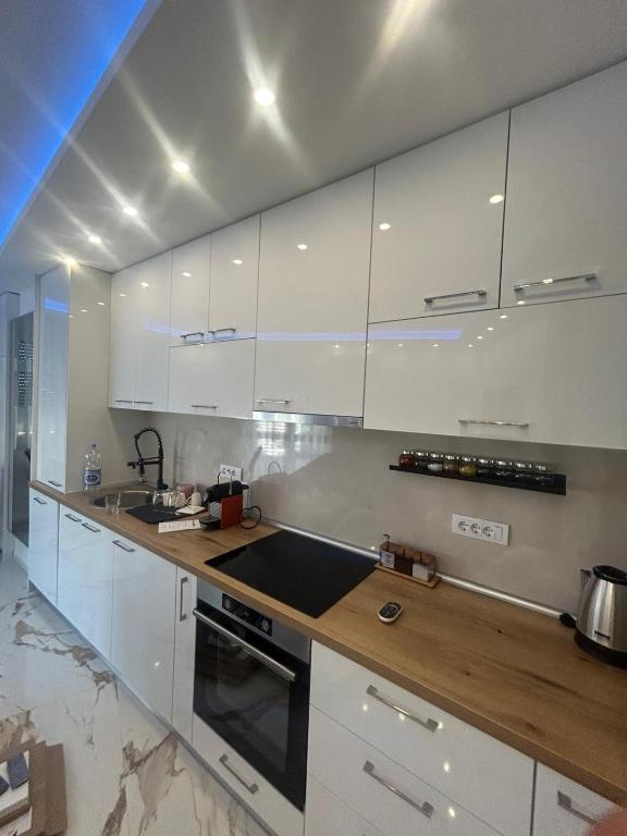 a kitchen with white cabinets and a stove top oven at Stan na dan Arte in Loznica