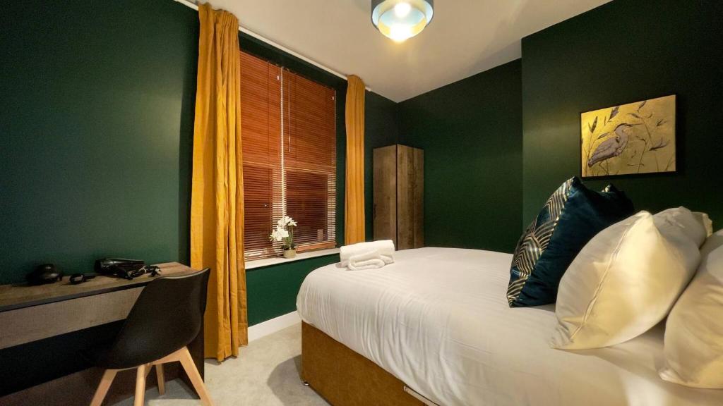 Schlafzimmer mit einem Bett mit grünen Wänden und einem Fenster in der Unterkunft Cosy 2-Bed Apartment - Nether Edge, Sheffield in Nether Edge