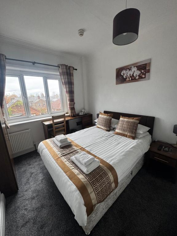 a bedroom with a large bed and two windows at Grange Lodge in York