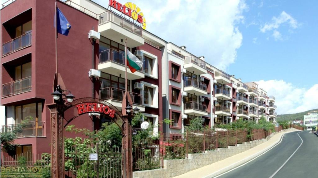 un edificio rosso sul lato di una strada di Studio Helios a Sveti Vlas