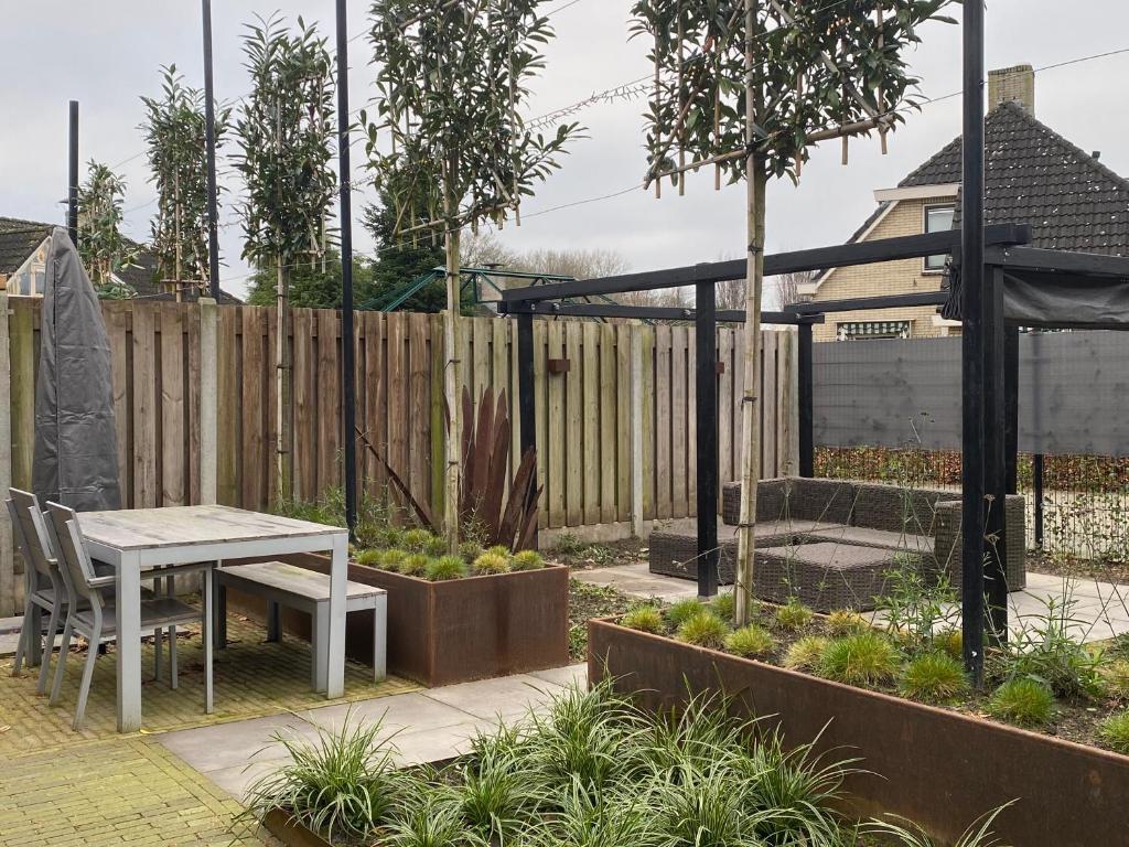 einen Garten mit einem Tisch und einem Zaun in der Unterkunft Hofstay Twente in Goor