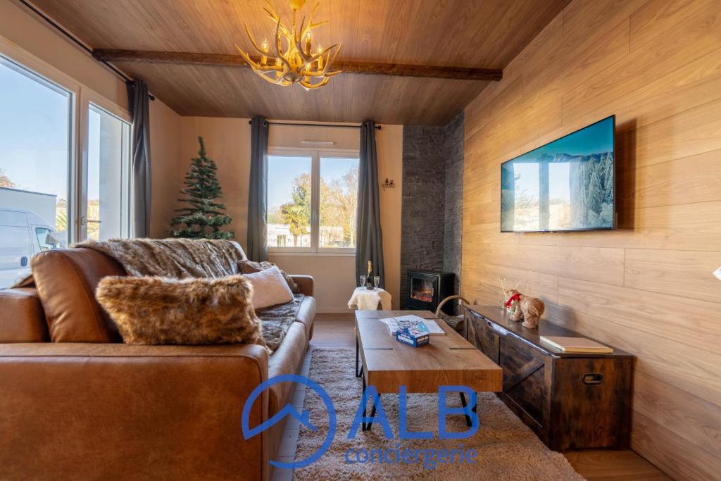 un salon avec un canapé et une table basse dans l'établissement Le Chalet Savoyard, à Hennebont