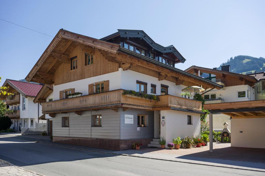 ein großes Gebäude mit einem Holzdach in der Unterkunft Haus Tiefenbacher in Brixen im Thale