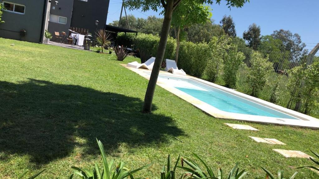 a swimming pool in a yard next to a house at Alquiler en Lobos, Empalme in Empalme Lobos