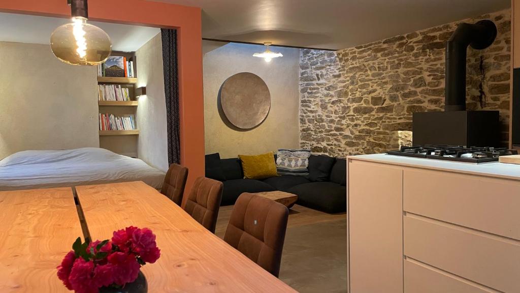 La Saulzaie في ليل ديو: مطبخ وغرفة معيشة مع طاولة وأريكة