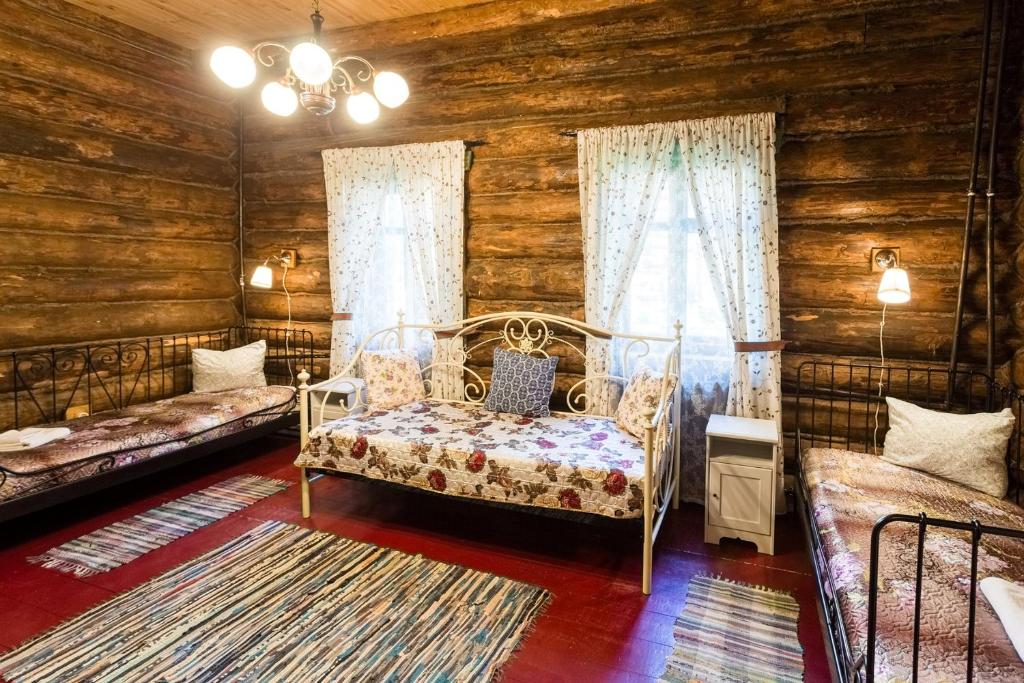 1 dormitorio con 1 cama en una cabaña de madera en Park Hotel Berendeevka, en Kostroma