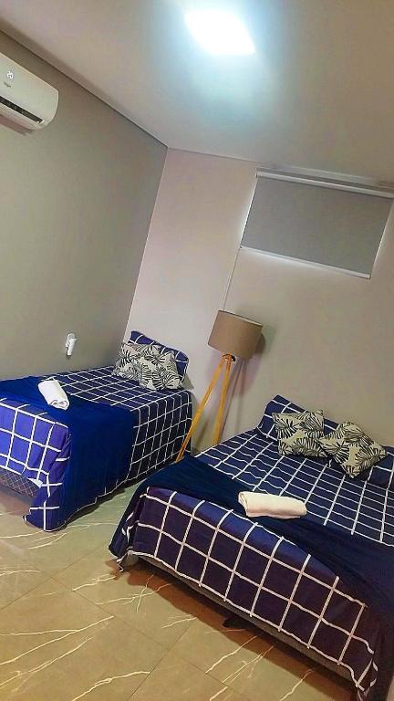 due letti in una stanza con blu e bianco di Flat Oásis- Super aconchegante a Tangará da Serra
