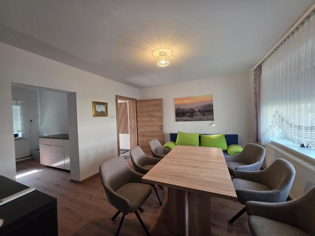 uma sala com uma mesa, cadeiras e um sofá em Ferienhaus Helene Güttenbach em Güttenbach