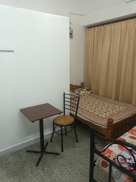 Camera con letto, scrivania e tavolo. di Giri Comforts a Mangalore