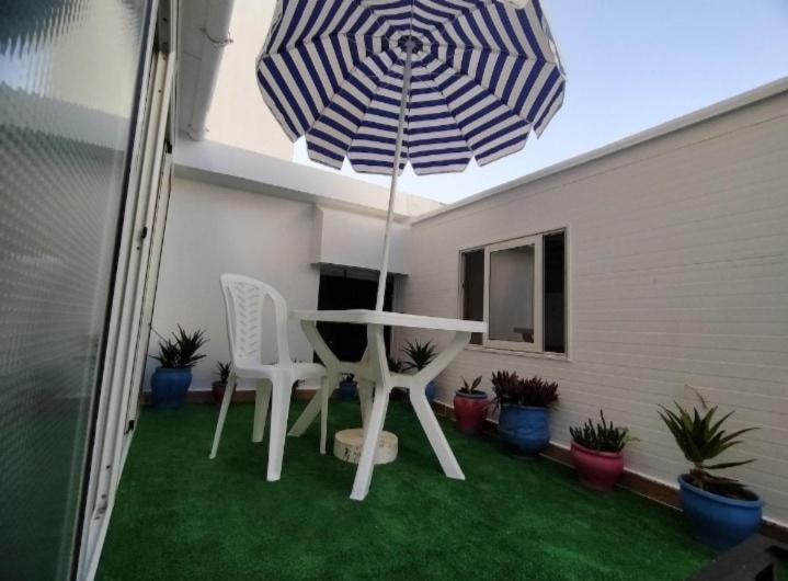 Un patio con una mesa y sillas y una sombrilla. en luxurious and quiet apartment, en Rabat