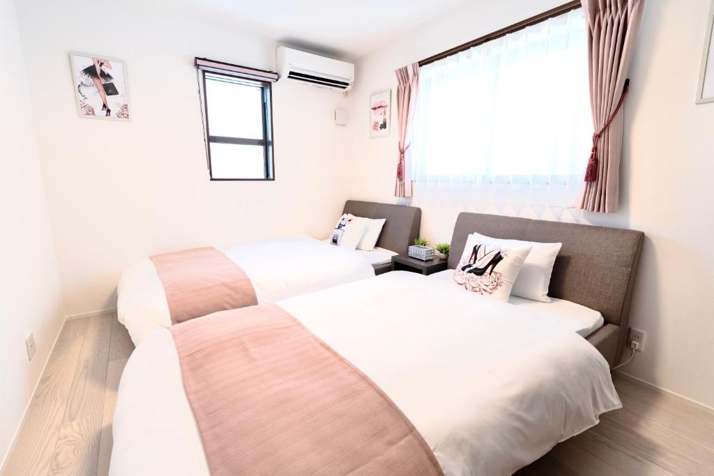 a bedroom with two beds and a window at sunshin dream in Osaka
