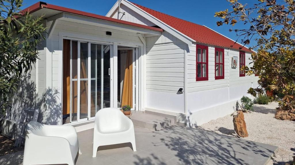a tiny house with two chairs and a door at Casa Boletes, with splendid views! in Cartagena