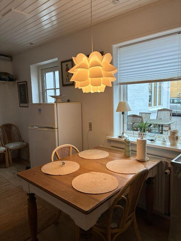 a kitchen with a table with chairs and a refrigerator at Lejlighed ved havet in Lønstrup
