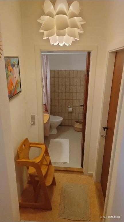 ein Bad mit einem WC und einem Kronleuchter in der Unterkunft Lejlighed ved havet in Lønstrup