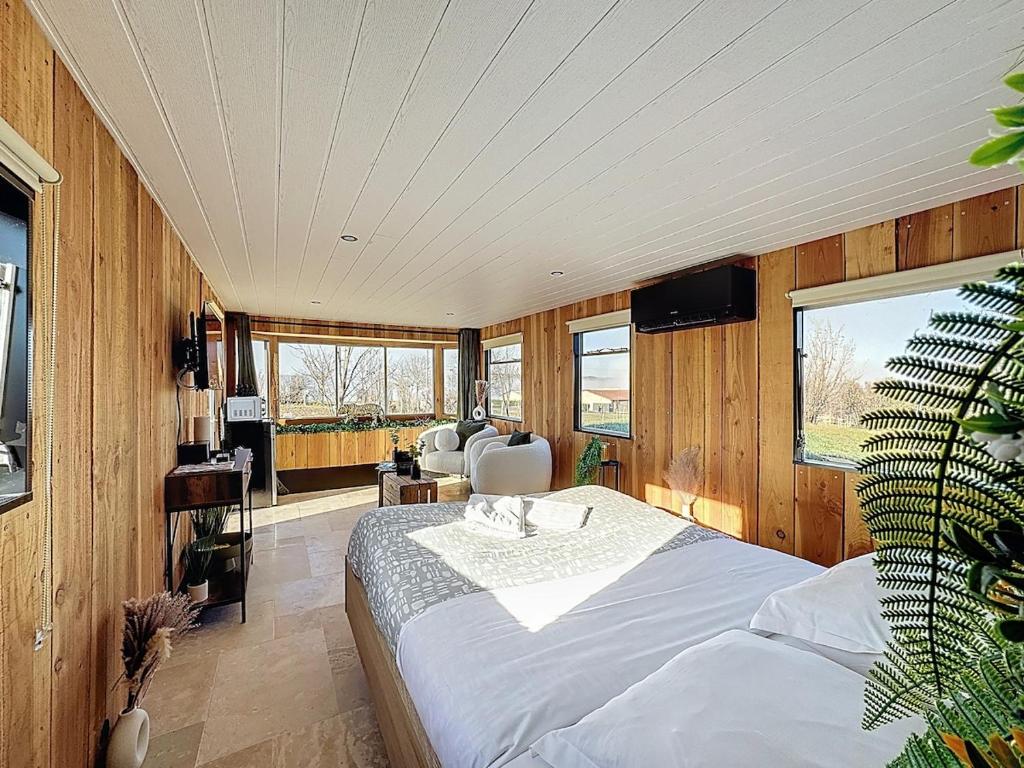 a bedroom with a bed in a room with wooden walls at Unique Cabane 4 spa Centre Équestre & Snack in Vic-le-Comte