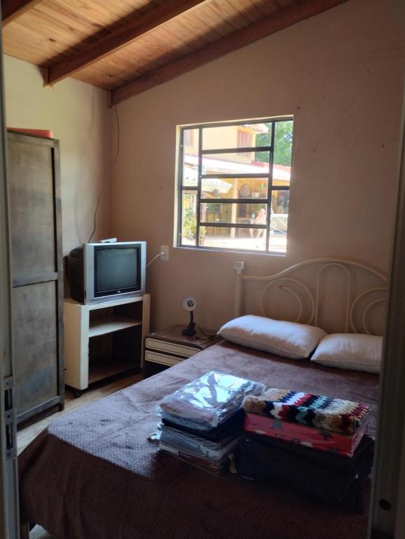 Un dormitorio con una cama y un televisor y una ventana. en Hospedaje Cabaña completa, en Rivera