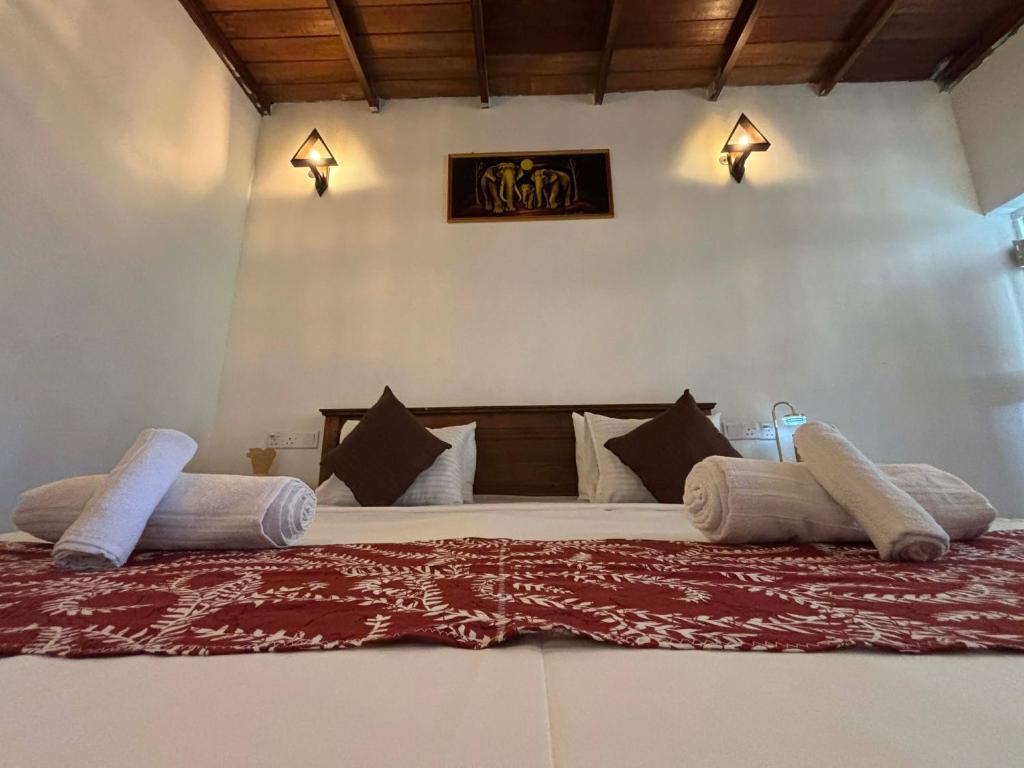 a bedroom with a large bed with pillows at Colonial Surfing Villa Hostel & Home Stay in Midigama East