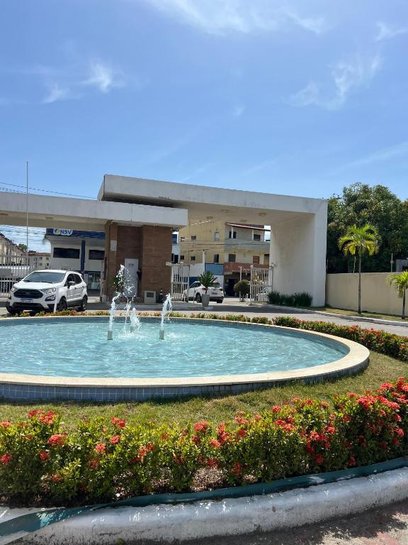 two people playing in a fountain in front of a building at VOG Torres do Sul Litoral Ilhéus in Ilhéus