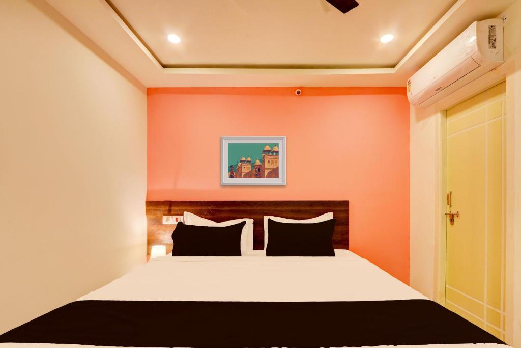 um quarto com uma cama com uma parede laranja em Hotel O S L N Grand em Upal