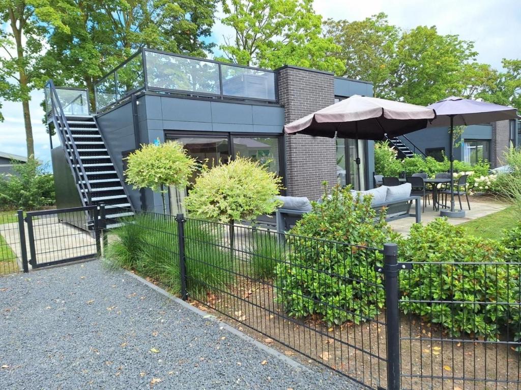 una casa con scala e ombrellone di Velduil 62 a Hulshorst