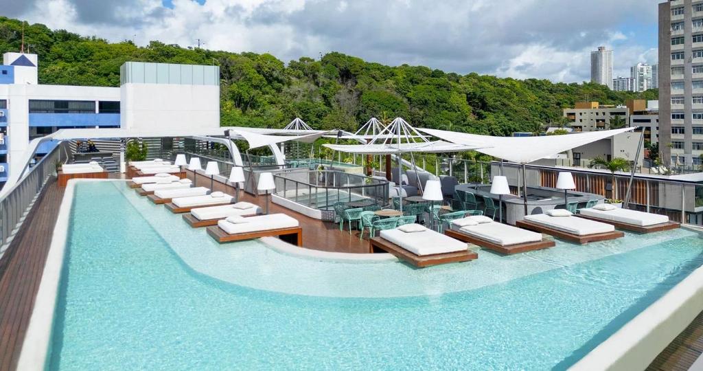 a pool on the top of a building with lounge chairs at Setai Yatch - Praia in João Pessoa