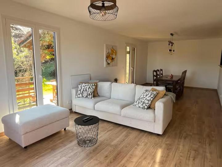 a living room with a white couch and a table at Le refuge de la fée in Fellering