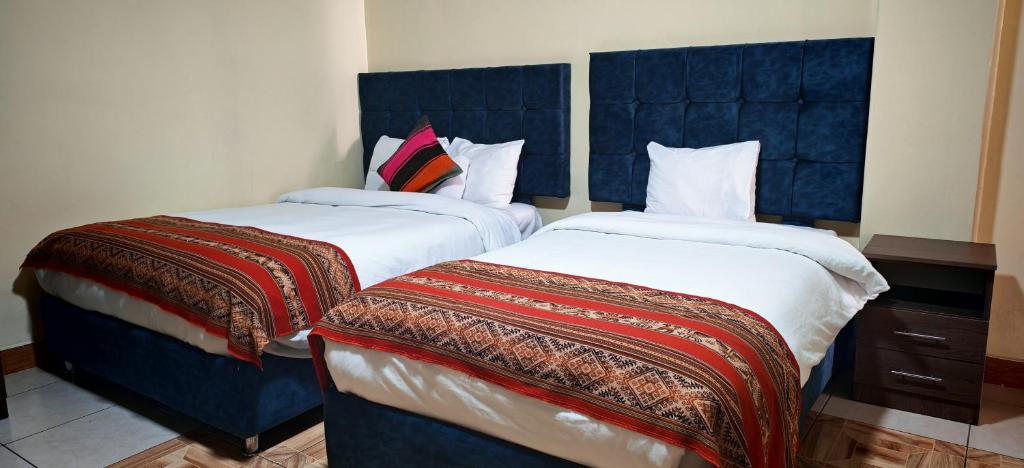 duas camas lado a lado em um quarto em hawka pacha cusqueña em Cusco