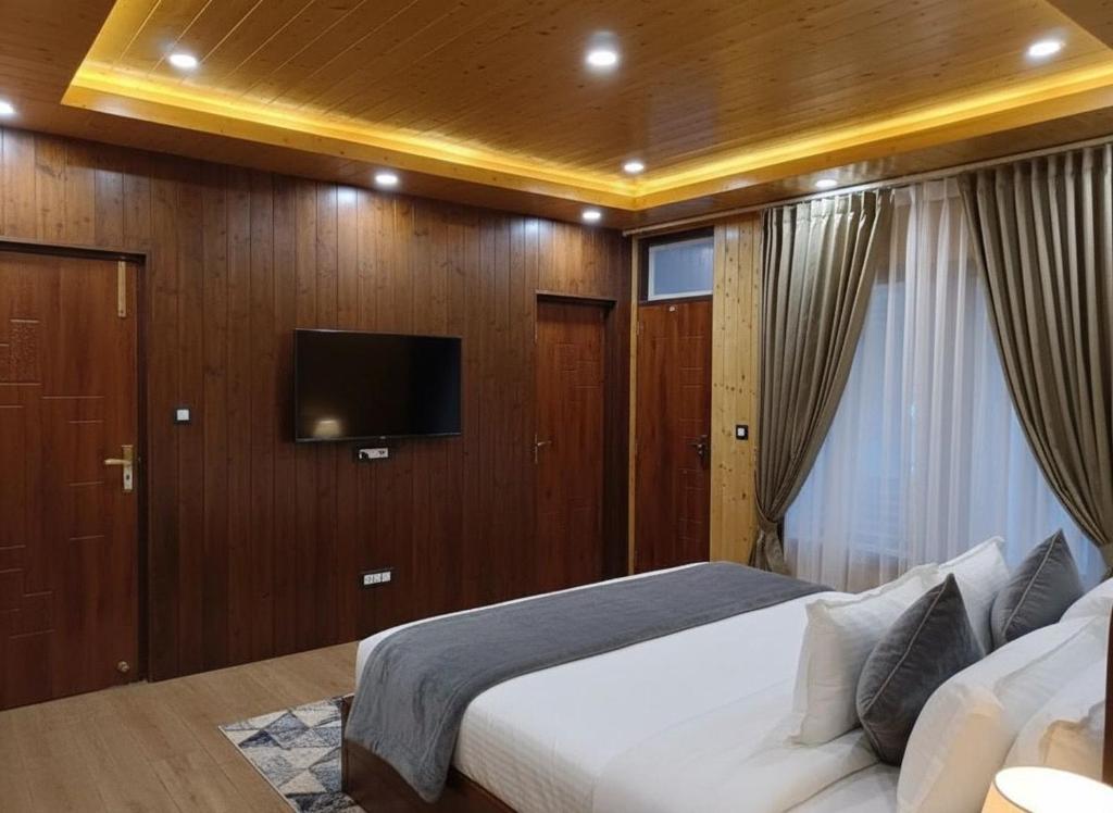 カソーリにあるThe Jungle View From Balconyのベッドと薄型テレビのある寝室