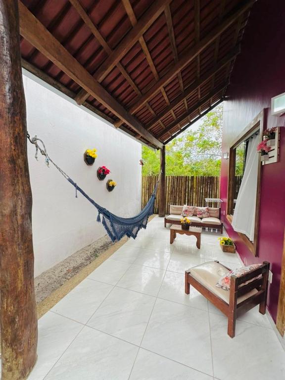 un porche avec un hamac dans une maison dans l'établissement Corumbau Chalé Casa, à Prado