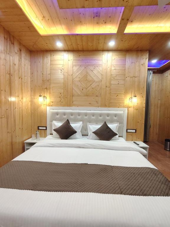 Un dormitorio con una gran cama blanca con paredes de madera. en Wood Luxury Hotels Kasauli, en Kasauli