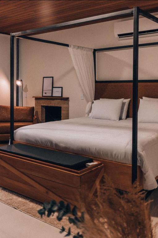 a bedroom with a canopy bed and a fireplace at Cabana Terra Nossa com vista in Marechal Floriano