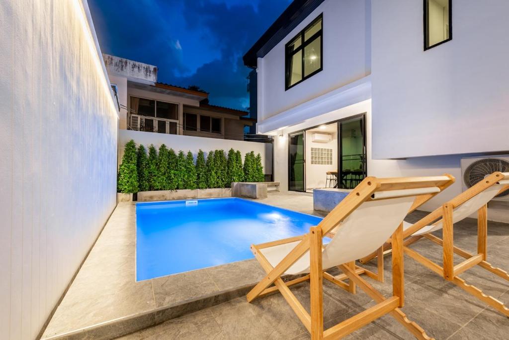 ein Swimmingpool im Hinterhof eines Hauses in der Unterkunft SavasdeeVilla Midtown bangkok in Makkasan