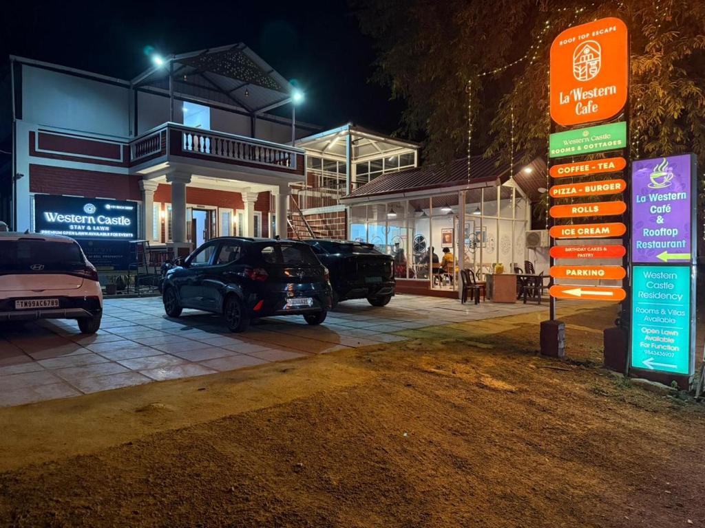 a group of cars parked in a parking lot at night at Western Castle Stay n lawn in Coimbatore