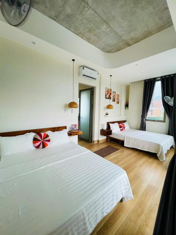 a bedroom with two beds and a couch at Khách Sạn Trung Loan in Ninh Hải