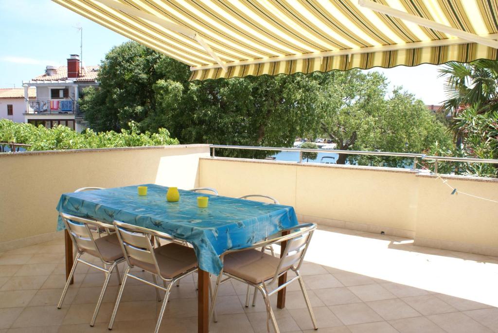 a table with chairs and a blue table cloth on a balcony at Apartment Adria Sun in Porat