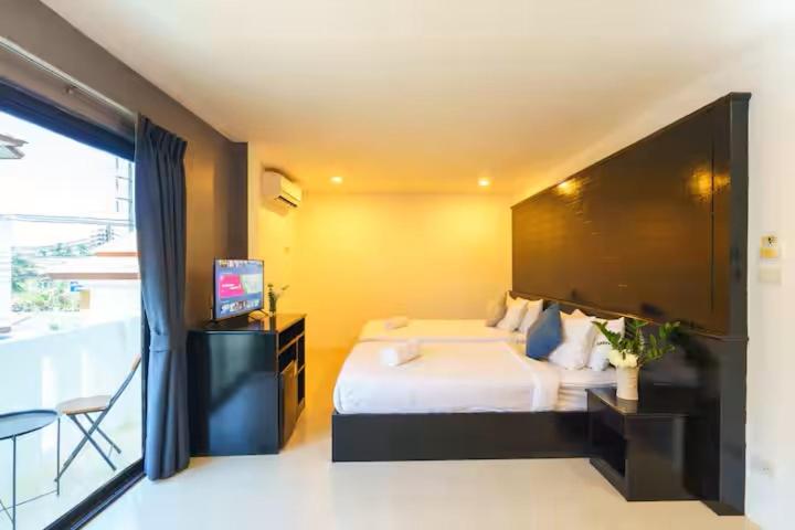 een slaapkamer met een bed en een flatscreen-tv bij AP Apartment in Kathu