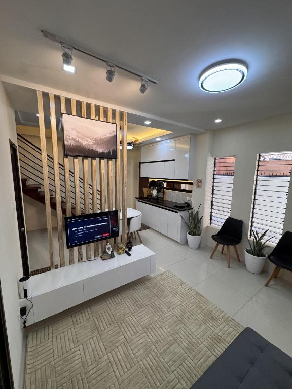 a living room with a television and a kitchen at Kugi Hostel - Self Check-in Capsule Hostel near Cebu Airport in Cogon