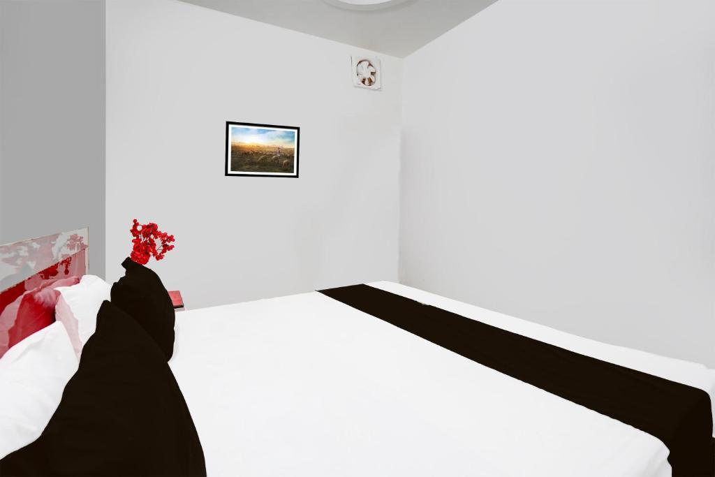 Camera bianca con letto e lenzuola bianche e nere di Hotel O by OYO The King Heaven a Bewar