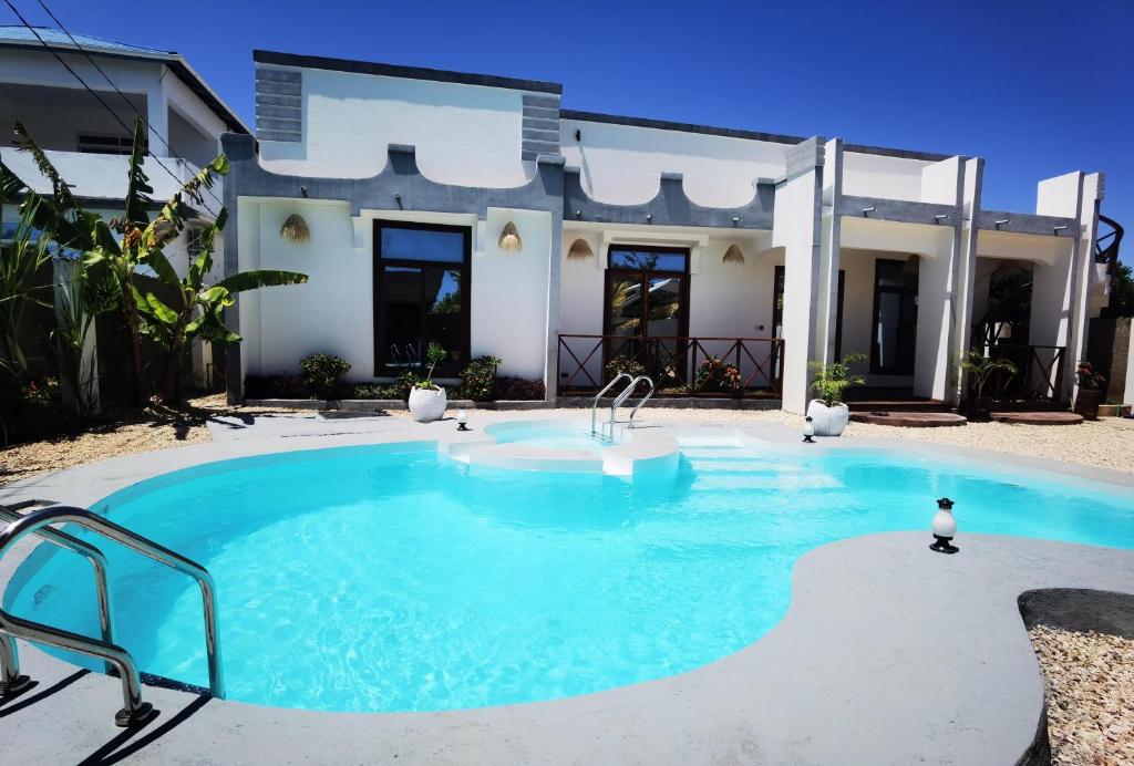 una piscina davanti a una casa di Villa Flower Zanzibar a Kiwengwa