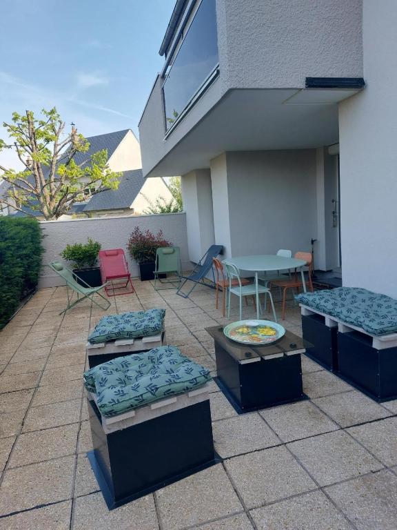 Super Apt terrasse 2box في اوليفيه: فناء به سريران وطاولة وكراسي