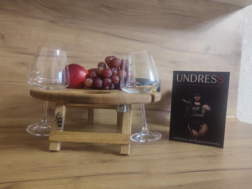 een miniatuurtafel met twee wijnglazen en een boek bij Тематичні апартаменти in Zhytomyr