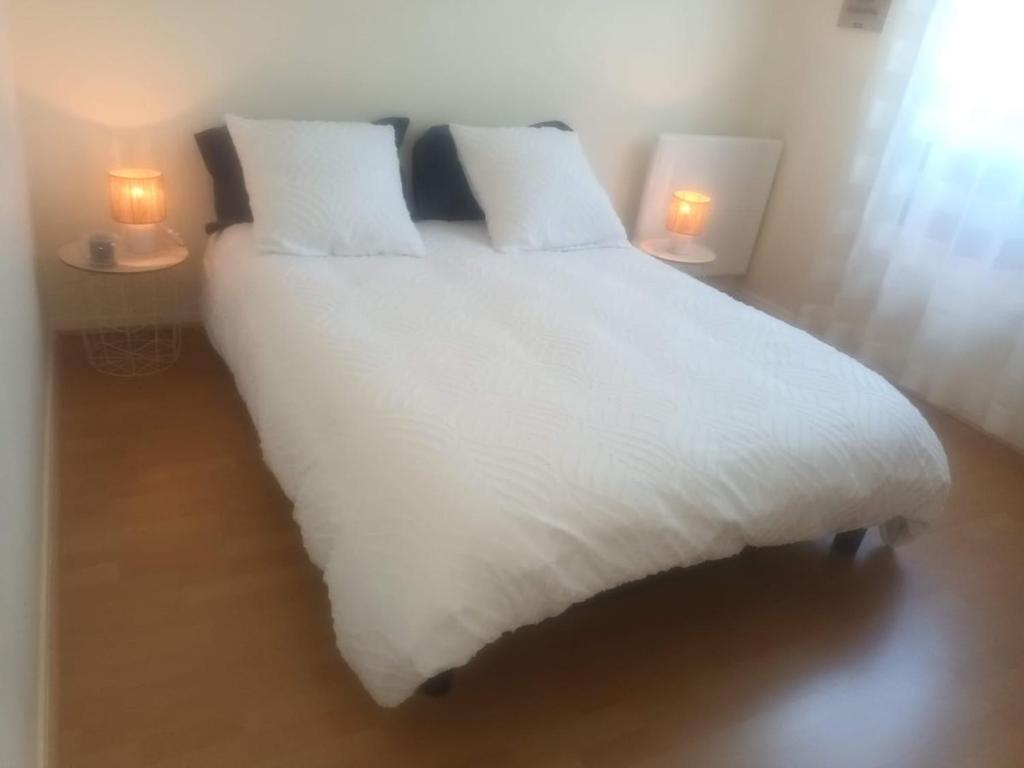 een wit bed met twee lampjes op twee tafels bij Super Apt terrasse 2box in Olivet