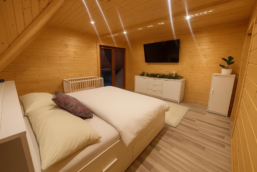 a small bedroom with a bed and a television at Villa Alexandra jacuzzi i sauna in Kościelisko