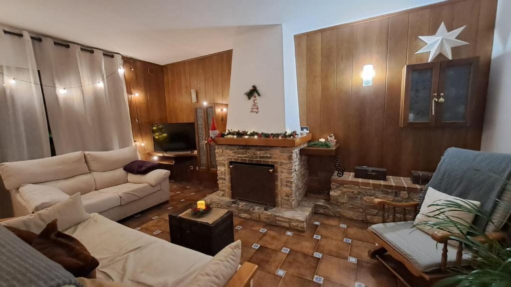 un soggiorno con divano e camino di Casa rural de estilo rústico a Bonastre