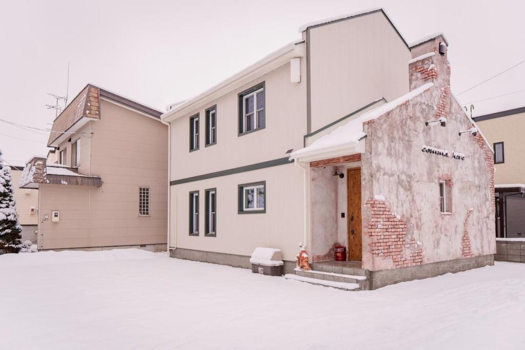una casa bianca con un edificio in mattoni di comma, here 