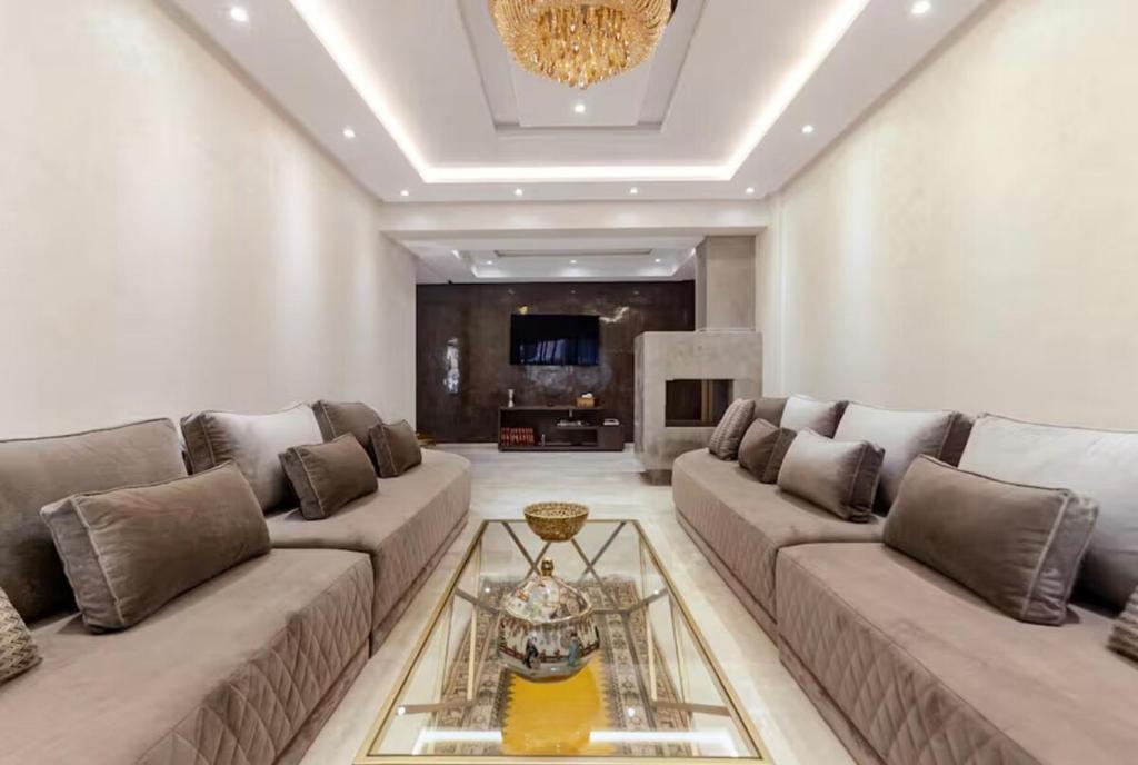 a living room with a large couch and a chandelier at Large Comfort Duplex Casablanca Center in LʼOasis